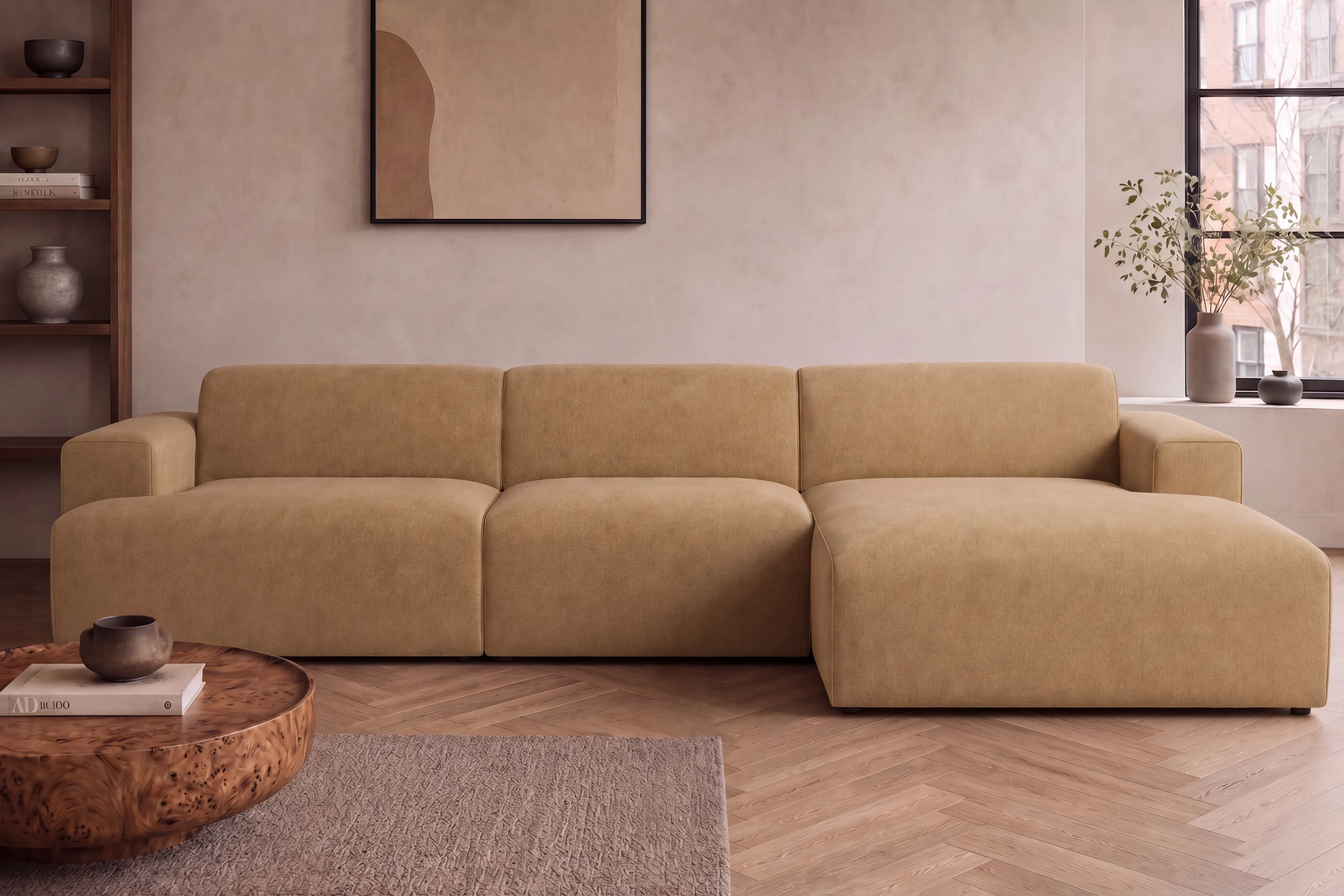 Camel modular sofa with a chaise, in a calm room with a low travertine table